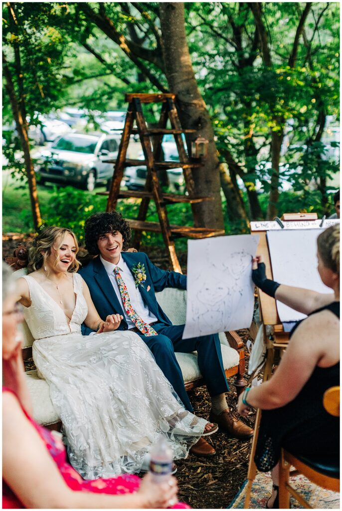 Couple posing with their caricature portraits at Wildflower Farm wedding in Friendsville, Tennessee