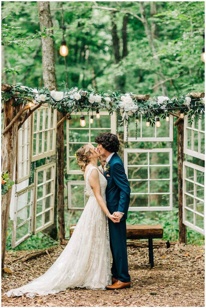 Bride Kali and groom Davis exchanging vows during their outdoor ceremony at Wildflower Farm in Friendsville, Tennessee